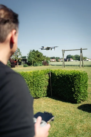 Fotograf mit Fernsteuerung und einer Drohne bei der Außenaufnahme