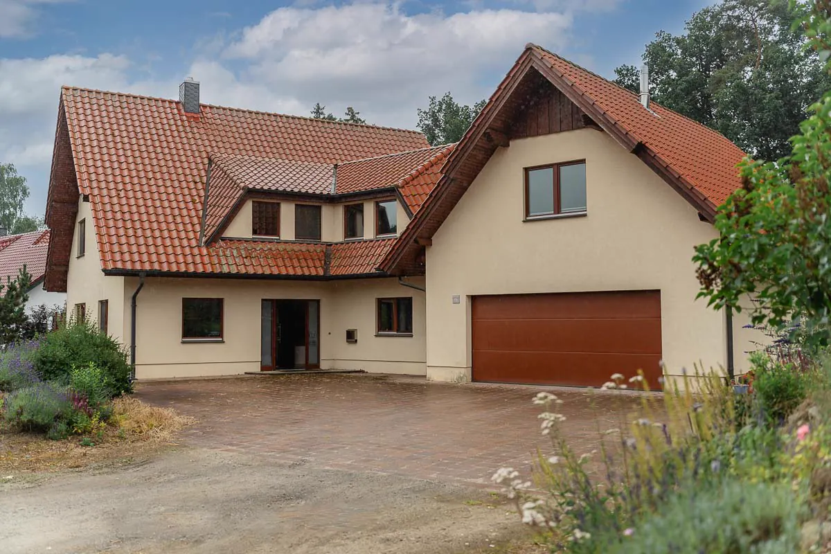 Außenansicht des bereits vermittelten Wohnhauses in Ostercappeln-Venne mit Ziegeldach und gepflasterter Zufahrt